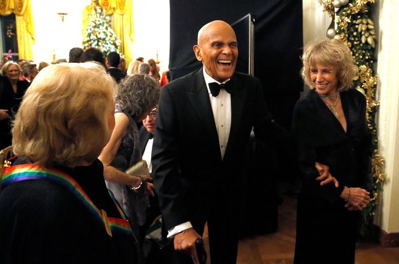 © Reuters. FILE PHOTO: Harry Belafonte (C) laughs with a fellow audience member as they depart after a reception for the 2013 Kennedy Center Honors recipients at the White House in Washington, December 8, 2013. REUTERS/Jonathan Ernst