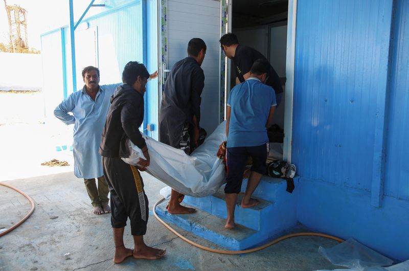 &copy; Reuters. أفراد يحملون جثة أحد المهاجرين ممن غرق قاربهم في البحر بعد أن انتشل خفر السواحل الليبي الجثث قبالة القره بوللي يوم الثلاثاء. تصوير حازم أحمد