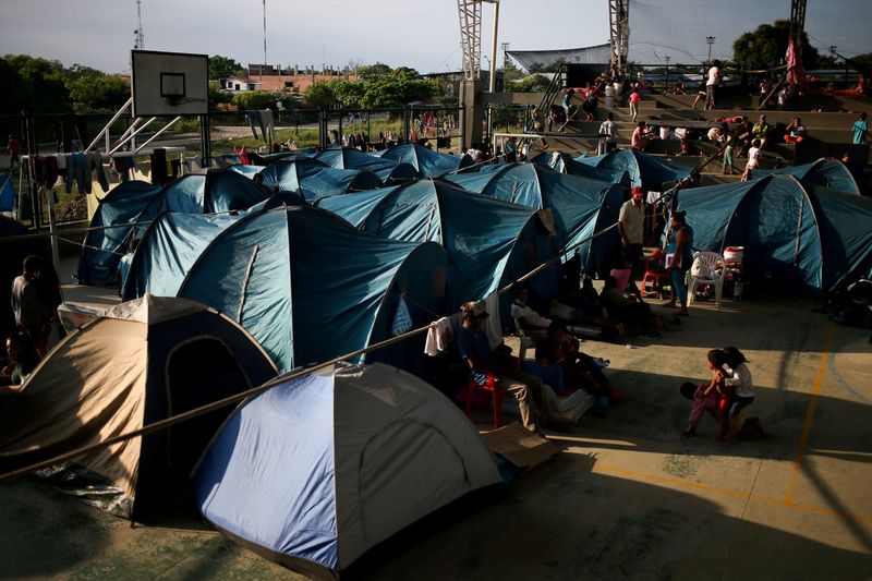 &copy; Reuters. FILE PHOTO: Venezuelan migrants are seen inside a coliseum where a temporary camp has been set up, after fleeing their country due to military operations, according to the Colombian migration agency, in Arauquita, Colombia March 27, 2021. REUTERS/Luisa Go