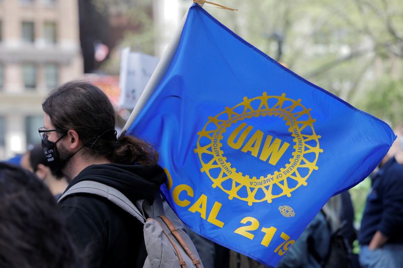 &copy; Reuters. FILE PHOTO: A person carries a flag with the patch from the United Auto Workers (UAW) labor union during a May Day rally on International Workers' Day in Manhattan, New York City, New York, U.S., May 1, 2021. REUTERS/Andrew Kelly