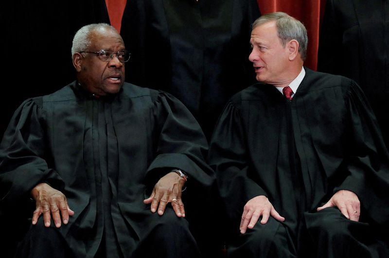 © Reuters. FILE PHOTO: U.S. Supreme Court Associate Justice Clarence Thomas (L) talks with Chief Justice John Roberts as the justices pose for their group portrait at the Supreme Court in Washington, U.S., November 30, 2018.  REUTERS/Jim Young/File Photo