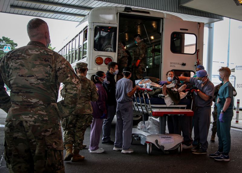 &copy; Reuters. جنود وطيارون ومدنيون أمريكيون يستقبلون المصابين خارج مطار حامد كرزاي الدولي ممن جرى إجلاؤهم إلى مركز طبي في ألمانيا يديره الجيش الأمريكي ي