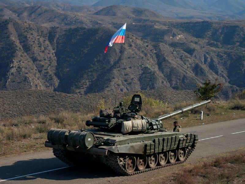 &copy; Reuters. جندي روسي من قوات حفظ السلام بقف بجوار دبابة ترفع علم روسيا قرب الحدود مع أرمينيا في صورة من أرشيف رويترز.
