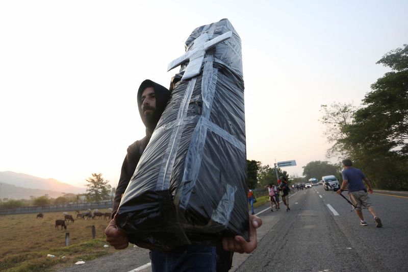 © Reuters. A migrant, detained for months in southern Mexico, carries a mock coffin in memory of an Honduran migrant who died of a heart attack as he continues his trip in a caravan heading for Mexico City to speed up the applications for U.S. asylum, in Huixtla, Chiapas state, Mexico, April 26, 2023. REUTERS/Gabriela Sanabria