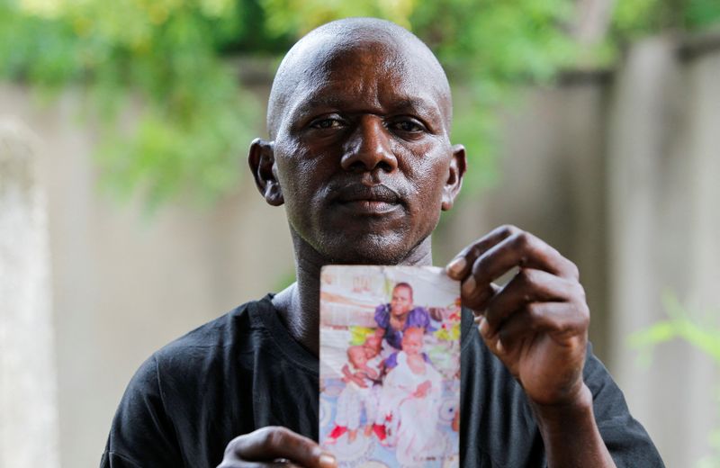 &copy; Reuters. Stephen Mwiti holds a photograph of his late wife Joan Bahati, a follower of a Christian cult named "Good News International Church", who believed they would go to heaven, if they starved themselves to death alongside his six children in Shakahola, outsid
