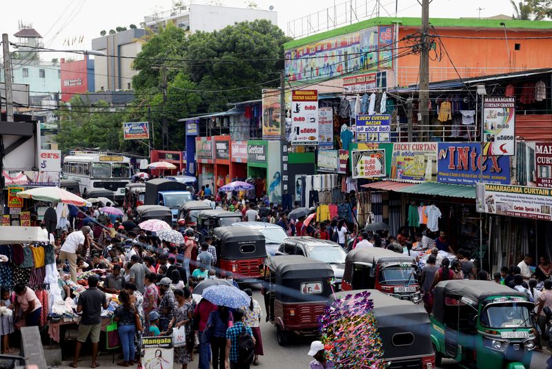 &copy; Reuters. FILE PHOTO: People gather around readymade clothing stalls to buy clothes ahead of the Sinhala and Tamil New Year festival, in Colombo, Sri Lanka April 11, 2023. REUTERS/Dinuka Liyanawatte