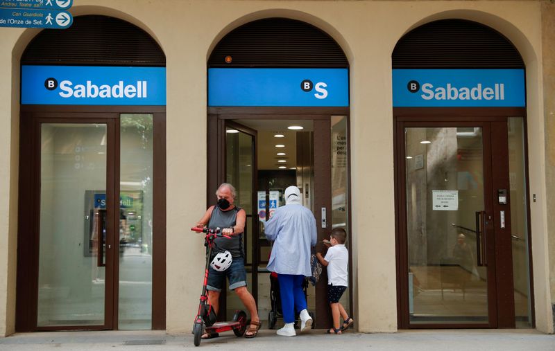 &copy; Reuters. FOTO DE ARCHIVO. Gente en la puerta de una oficina del banco Sabadell en Barcelona, Cataluña, España