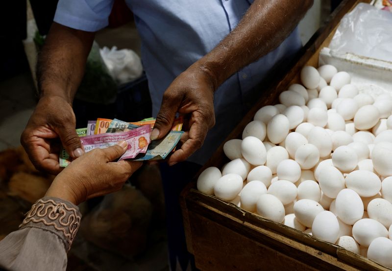 &copy; Reuters. FILE PHOTO: A vendor gives change to a customer after selling eggs amid the rampant food inflation, amid Sri Lanka's economic crisis, in Colombo, Sri Lanka, July 29 , 2022. REUTERS/Kim Kyung-Hoon