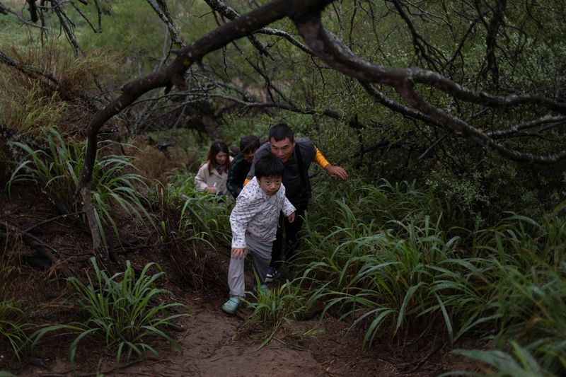 &copy; Reuters. Migrants from China emerge from thick brush after being smuggled across the Rio Grande river into the United States from Mexico in Fronton, Texas, U.S., April 7, 2023.   REUTERS/Staff       