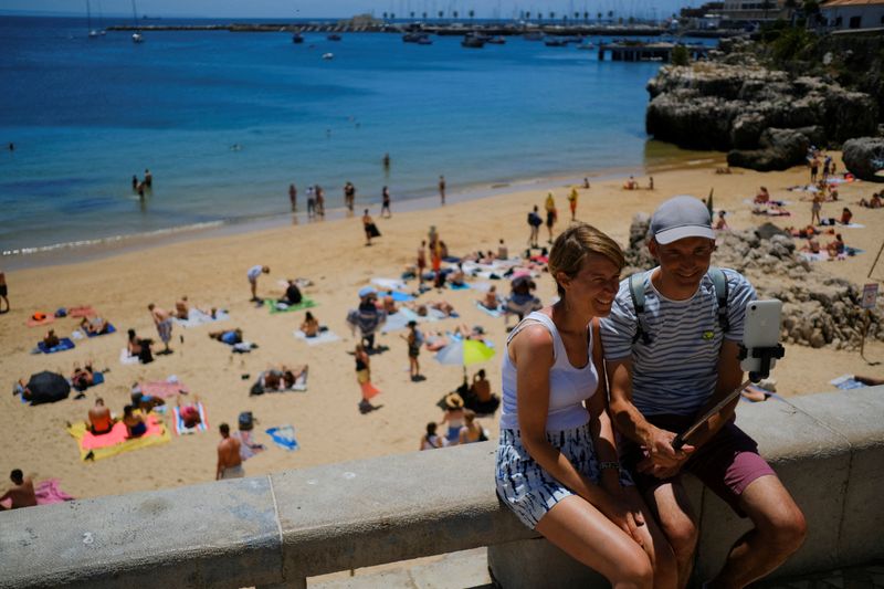 &copy; Reuters. FILE PHOTO: Tourists take a photo near a beach in Cascais, Portugal, June 6, 2022. Picture taken June 6, 2022. REUTERS/Pedro Nunes/File Photo