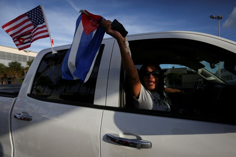 &copy; Reuters. FILE PHOTO: A woman shouts and waves a Cuban flag as drives past outside Versailles restaurant, where emigres gather in reaction to reports of protests in Cuba against its deteriorating economy, in Miami, Florida, U.S. July 18, 2021. REUTERS/Marco Bello/F