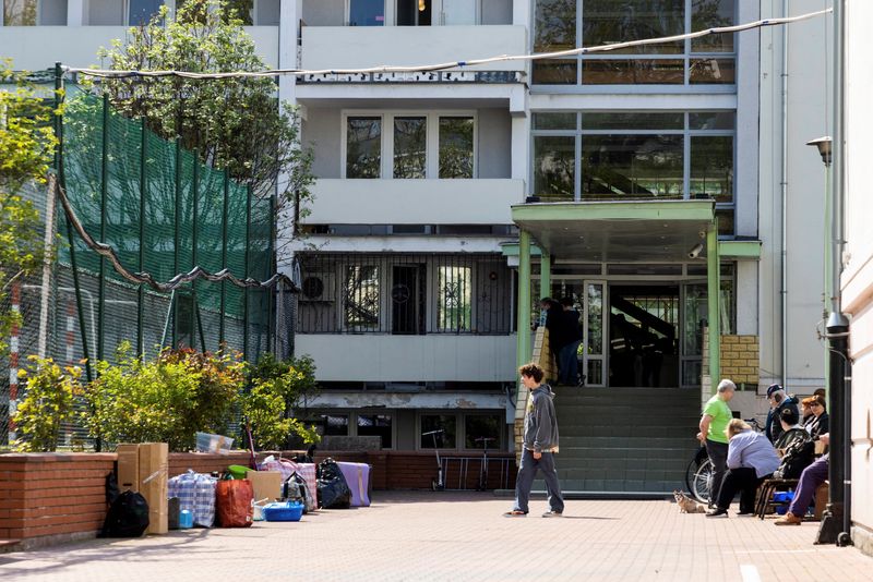 © Reuters. A group of people are gathered in front of the school entrance next to items taken out of the building after Poland seized the Russian embassy school in Warsaw, Poland, April 29, 2023. REUTERS/Kuba Stezycki