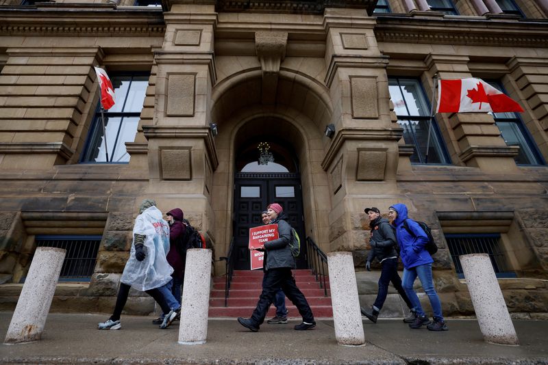 &copy; Reuters. محتجون يسيرون حول مكتب رئيس الوزراء ومجلس الملكة الخاص حيث يواصل عمال بنقابات القطاع العام و تحالف الخدمة العامة الكندي الإضراب في أوتاوا ي