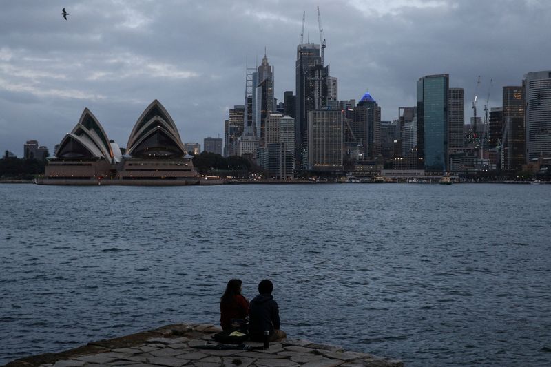 &copy; Reuters. FILE PHOTO: People sit on a waterfront ledge looking toward the Sydney city centre skyline and Opera House amidst the easing of the coronavirus disease (COVID-19) restrictions in Sydney, Australia, May 26, 2020.  REUTERS/Loren Elliott/File Photo