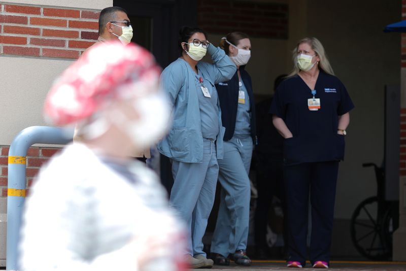 &copy; Reuters. FILE PHOTO: Nurses stand in a hospital doorway watching a nurses’ protest for personal protective equipment at UCLA Medical Center, as the spread of the coronavirus disease (COVID-19) continues, in Los Angeles, California, U.S., April 13, 2020.  REUTERS