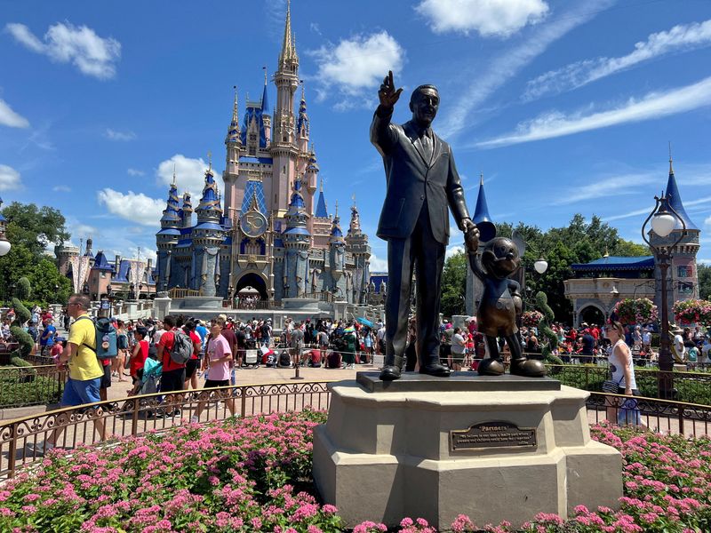 © Reuters. FILE PHOTO: People gather at the Magic Kingdom theme park before the 