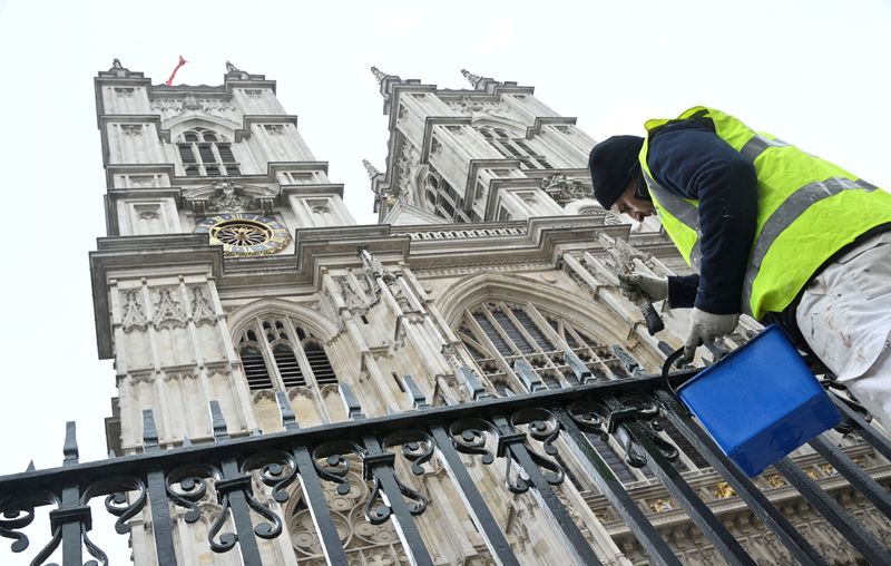 &copy; Reuters. FILE PHOTO: A worker paints railings in preparation of the Coronation of King Charles III, outside of Westminster Abbey in London, Britain, April 19, 2023. REUTERS/Toby Melville/File Photo