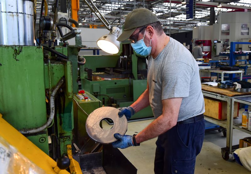 &copy; Reuters. FILE PHOTO: A worker at the Liebherr manufacturing company, which produces gear cutting tools, wears a protective mask and gloves as he works in the factory a day after its re-opened, as Italy begins a staged end to a nationwide lockdown due to a spread o