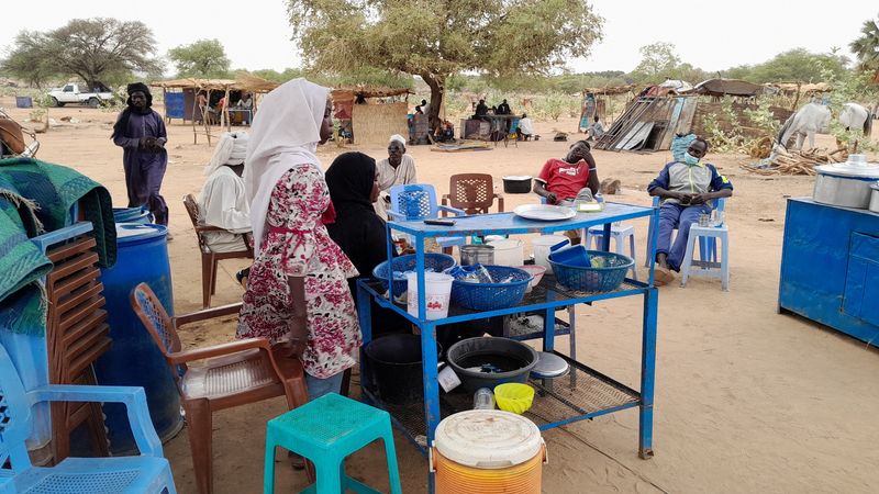 &copy; Reuters. FILE PHOTO: Fatma Dahab Ousman, a Sudanese refugee who fled the violence in her country, sells tea and porridge to other refugees near the border between Sudan and Chad, in Koufroun, Chad May 1, 2023. REUTERS/Mahamat Ramadane  REFILE - CORRECTING SPELLING