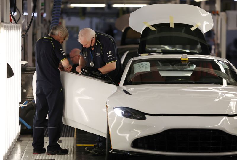 © Reuters. FILE PHOTO: Employees work on a car at the Aston Martin factory in Gaydon, Britain, March 16, 2022. Picture taken March 16, 2022. REUTERS/Phil Noble