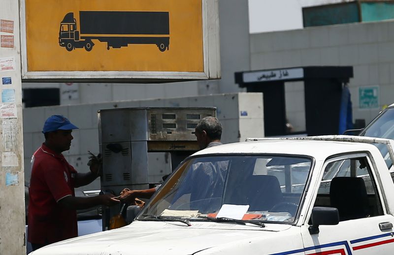 &copy; Reuters. أحد الزبائن في محطة للوقود يدفع ثمن وقود السولار للعامل بالمحطة في صورة من أرشيف رويترز