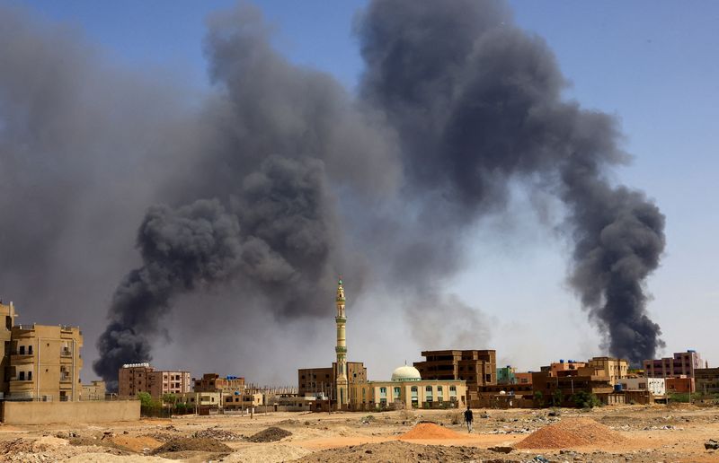 &copy; Reuters. FILE PHOTO: A man walks while smoke rises above buildings after aerial bombardment, during clashes between the paramilitary Rapid Support Forces and the army in Khartoum North, Sudan, May 1, 2023. REUTERS/Mohamed Nureldin Abdallah  