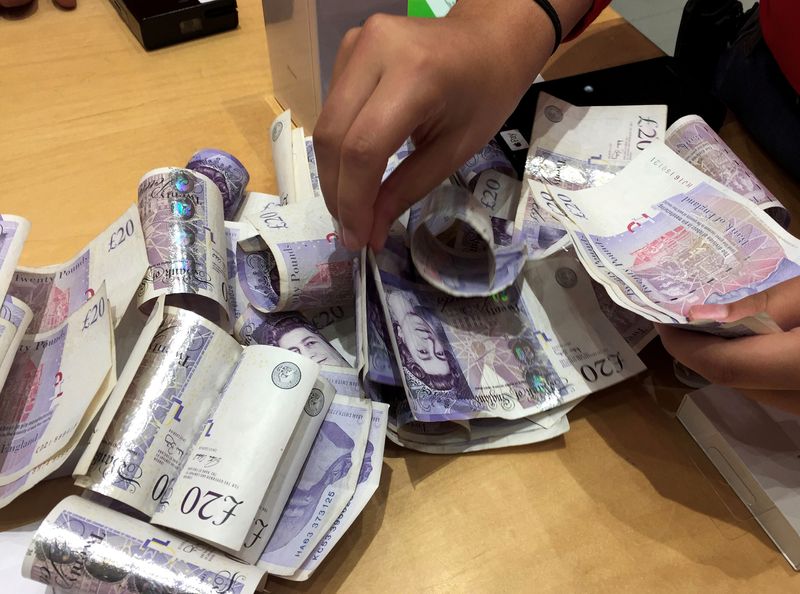 &copy; Reuters. FILE PHOTO: A shop assistant counts piles of British Pound Sterling banknotes at an Apple store in London, Britain November 18, 2017. REUTERS/Russell Boyce