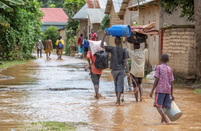 &copy; Reuters. أفراد يخوضون في مياه فيضانات نجمت عن أمطار غزيرة في رواندا في صورة يوم الاربعاء. تصوير: جان بيزيمانا - رويترز. 