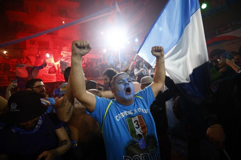 © Reuters. مشجعو نادي نابولي يحتفلون بفوز الفريق بلقب دوري الدرجة الأولى الإيطالي لكرة القدم في نابولي يوم الخميس. تصوير: جوليلمو مانجاباني – رويترز.