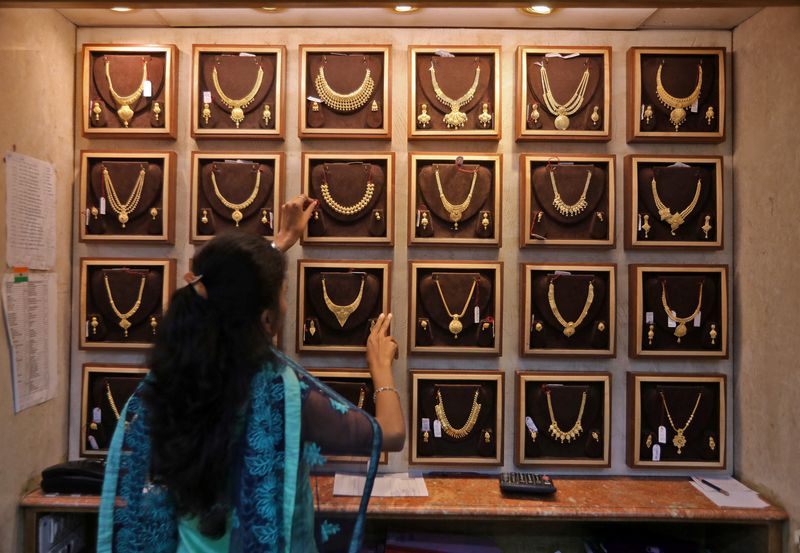 &copy; Reuters. FILE PHOTO: A saleswoman shows a gold necklace to a customer at a jewellery showroom during Dhanteras, a Hindu festival associated with Lakshmi, the goddess of wealth, in Mumbai, India, October 22, 2022. REUTERS/Niharika Kulkarni