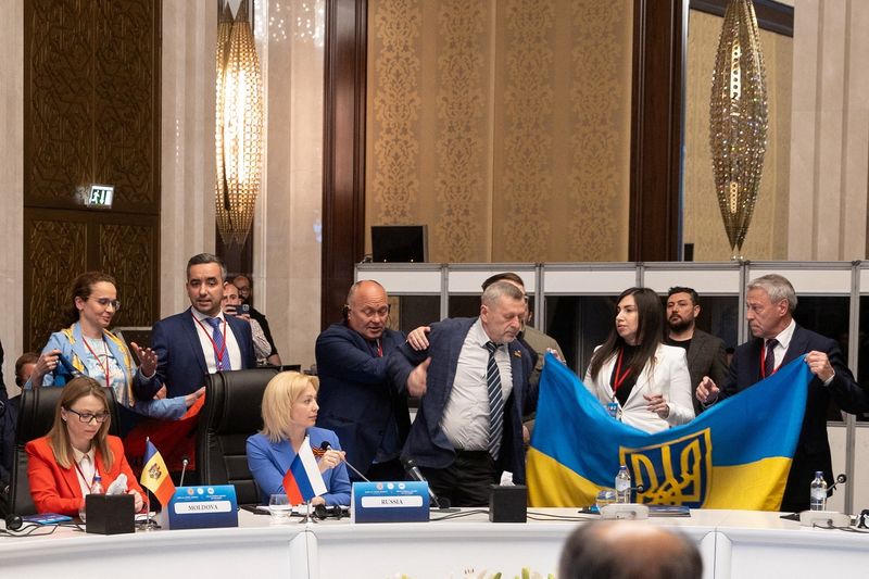 © Reuters. Members of Ukrainian delegation unfurl their national flag next to Olga Timofeeva, deputy head of Russian delegation, to disrupt her speech during a meeting of the Parliamentary Assembly of the Black Sea Economic Cooperation (PABSEC) in Ankara, Turkey May 4, 2023. Edib Kurt/Turkish Grand National Assembly, TBMM/Handout via REUTERS 