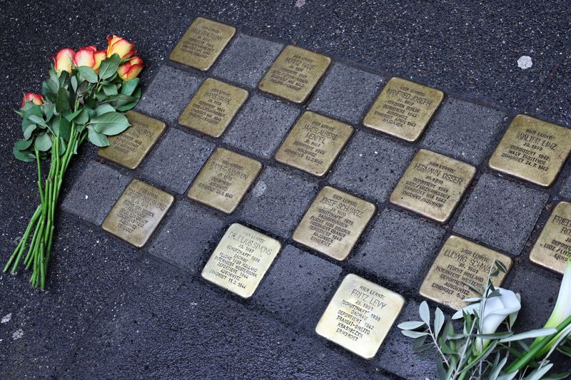 © Reuters. Flowers are placed next to Stumbling stones (Stolpersteine) of artist Gunter Demnig following a stone laying ceremony for a former teacher and a former pupil of the Deutzer Gymnasium Schaurtestrasse in Cologne, Germany, March 8, 2023.  REUTERS/Wolfgang Rattay