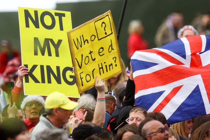&copy; Reuters. Des gens tiennent des pancartes le jour de la cérémonie de couronnement du roi Charles de Grande-Bretagne, sur l'avenue The Mall à Londres. /Photo prise le 6 mai 2023/REUTERS/Paul Childs
