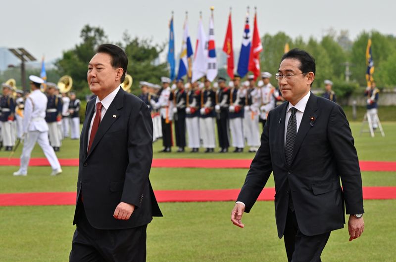 © Reuters. Japanese Prime Minister Fumio Kishida and South Korean President Yoon Suk Yeol attend a welcoming ceremony at the presidential office in Seoul on May 7, 2023.     JUNG YEON-JE/Pool via REUTERS