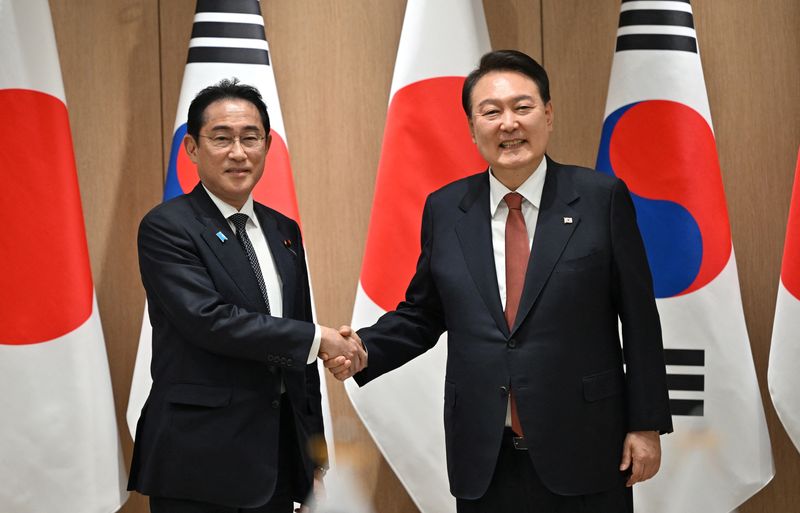 &copy; Reuters. يون سوك يول رئيس كوريا الجنوبية يصافح رئيس الوزراء الياباني فوميو كيشيدا قبل اجتماع في المكتب الرئاسي في سول يوم الأحد. صورة لرويترز من ممثل