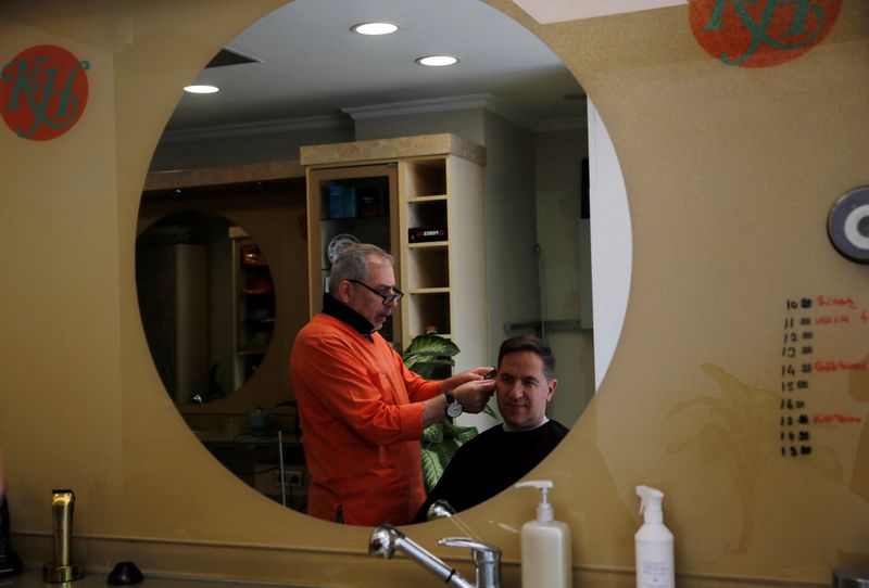 © Reuters. FILE PHOTO: Barber Hakim Ekinci cuts his customer's hair at his shop in Istanbul, Turkey May 4, 2023. REUTERS/Dilara Senkaya