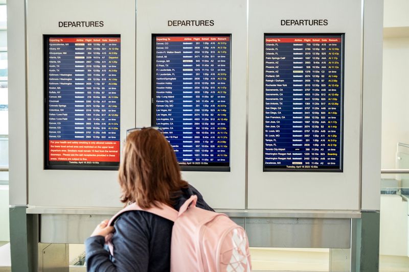 &copy; Reuters. FOTO DE ARCHIVO. Una mujer comprueba el tablero de llegadas y salidas en el Aeropuerto Internacional Midway de Chicago, en Chicago, Illinois, Estados Unidos. 18 de abril de 2023. REUTERS/Jim Vondruska