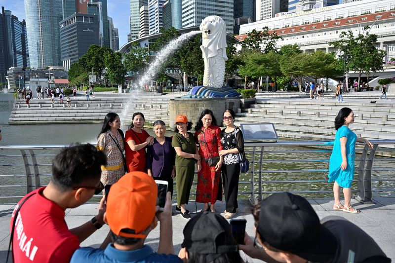 &copy; Reuters. FILE PHOTO: Tourists pose for photographs at Merlion Park in Singapore January 27, 2023. REUTERS/Caroline Chia/File Photo