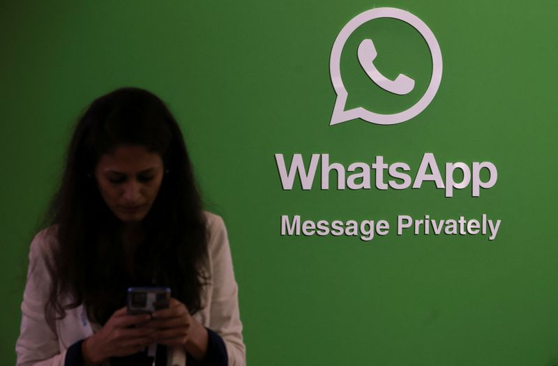 &copy; Reuters. FILE PHOTO: A woman uses her phone next to a logo of the WhatsApp application during Global Fintech Fest in Mumbai, India September 20, 2022. REUTERS/Francis Mascarenhas