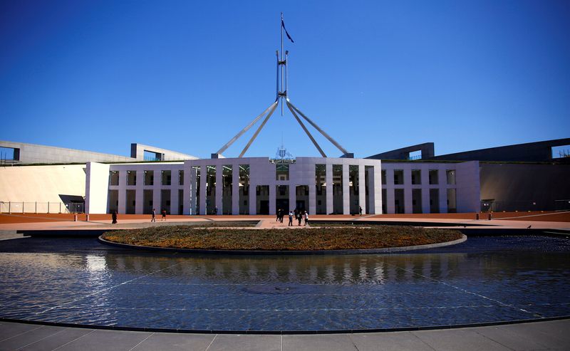 © Reuters. FILE PHOTO: Tourists walk around the forecourt of Australia's Parliament House in Canberra, Australia, October 16, 2017. REUTERS/David Gray