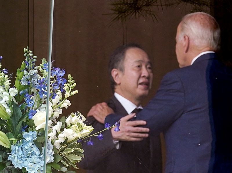 &copy; Reuters. FILE PHOTO: U.S. President Joe Biden is seen through a window being embraced by Japan's Ambassador to the U.S. Tomita Koji before signing a book of condolence in memory of Japan's former Prime Minister Shinzo Abe, who was fatally shot while campaigning fo