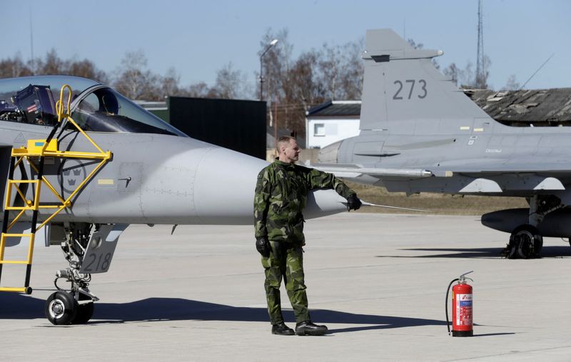 &copy; Reuters. FILE PHOTO: An airmen takes a break in front of a Swedish Grippen fighter aircraft during a joint NATO military exercise in Siauliai April 1, 2014.   REUTERS/Ints Kalnins