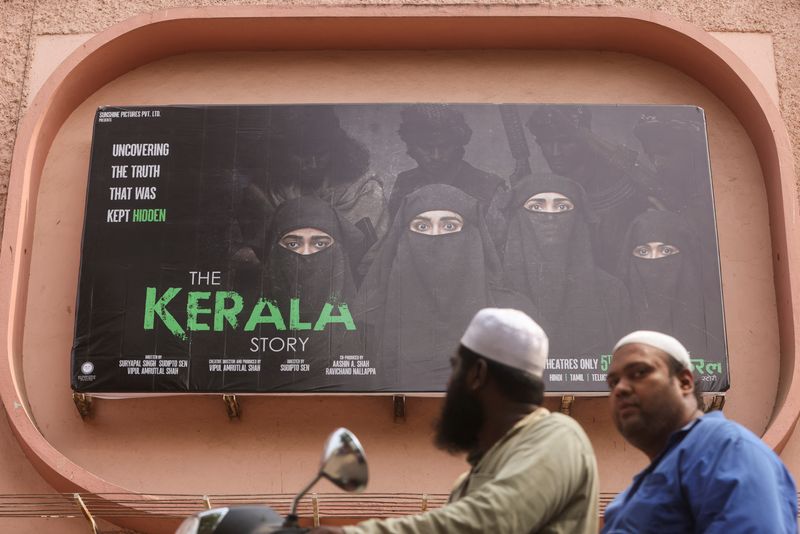 &copy; Reuters. رجلان على ظهر دراجة نارية يمران أمام ملصق يروج لفيلم "قصة كيرالا" الهندي خارج إحدى دور العرض السينمائي في مومباي يوم الثلاثاء. تصوير: فرانسيس