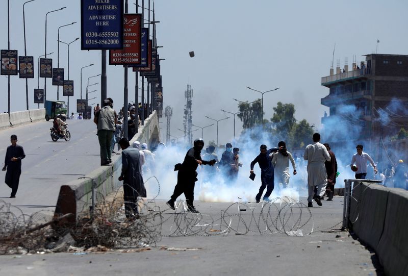 &copy; Reuters. داعمون لرئيس الوزراء السابق عمران خان يلقون الحجارة على الشرطة خلال الاحتجاجات في باكستان يوم الأربعاء. تصوير: فايز عزيز - رويترز.