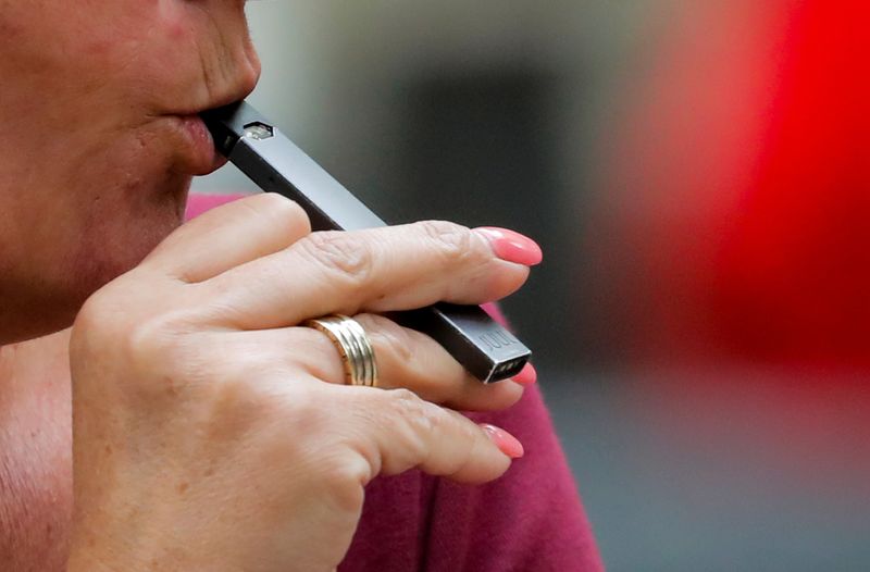 © Reuters. FILE PHOTO: A woman smokes a Juul e-cigarette in New York, U.S., September 27, 2018.  REUTERS/Brendan McDermid