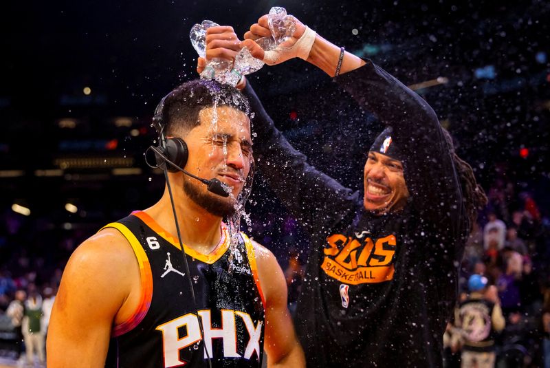 &copy; Reuters. FILE PHOTO: Dec 17, 2022; Phoenix, Arizona, USA; Phoenix Suns guard Devin Booker has water dumped on him by teammate Damion Lee after defeating the New Orleans Pelicans at Footprint Center. Mandatory Credit: Mark J. Rebilas-USA TODAY Sports/File Photo