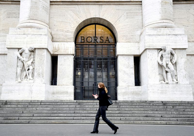 &copy; Reuters. FILE PHOTO: A woman walks past the Italian Stock Exchange in Milan, Italy, February 25, 2020. REUTERS/Flavio Lo Scalzo//File Photo
