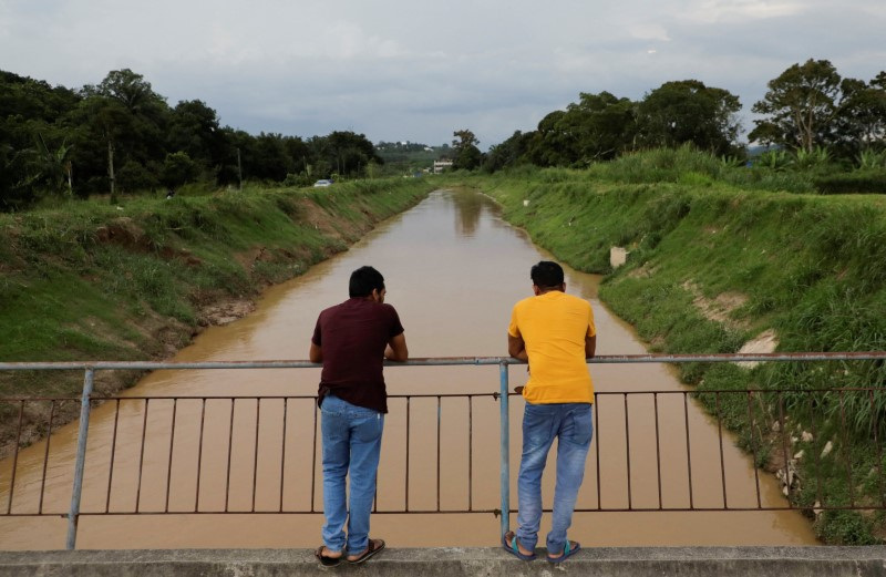 © Reuters. South Asian migrant workers stand on a bridge in Sepang, Malaysia May 2, 2023. REUTERS/Hasnoor Hussain