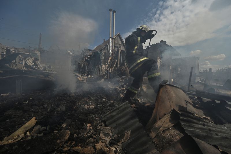 © Reuters. A firefighter works at a site of a residential house destroyed by a Russian military strike, amid Russia's attack on Ukraine, in the village of Malokaterynivka, Zaporizhzhia region, Ukraine May 11, 2023. REUTERS/Stringer