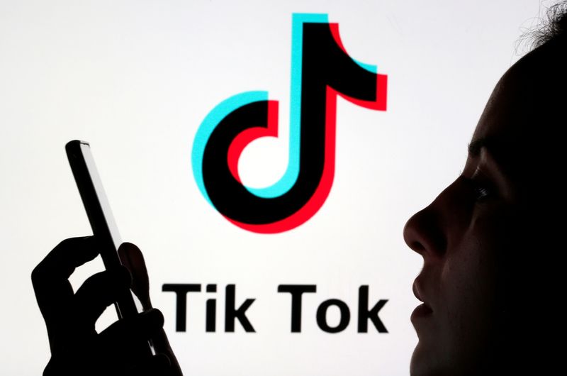 &copy; Reuters. FILE PHOTO: A person holds a smartphone as Tik Tok logo is displayed behind in this picture illustration taken November 7, 2019. Picture taken November 7, 2019. REUTERS/Dado Ruvic/Illustration